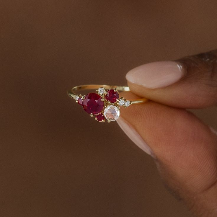 Round ruby focal (5mm, SI clarity). Side cluster stones ranging from 1.5mm to 3.5mm, SI1 clarity, G+ color round and round rose cut diamonds, AA round natural rubies. Solid 14k gold setting with a delicate 1.2mm round band. Also available in platinum. We handcraft each piece with responsibly sourced metals and ethically sourced stones. Luxury Ruby Multi-stone Cluster Ring, Ruby And Diamond Cluster Ring, Ruby And Moonstone Ring, Ruby Cluster Ring, Ruby Birthstone Promise Ring With Rose Cut Diamonds, Fine Jewelry Ruby Birthstone Ring With Rose Cut Diamonds, 14k Gold Red Cluster Ring With Rose Cut Diamonds, Cluster Ruby Ring With Rose Cut Diamonds, Lab-created Ruby Rings With Rose Cut Diamonds For Promise