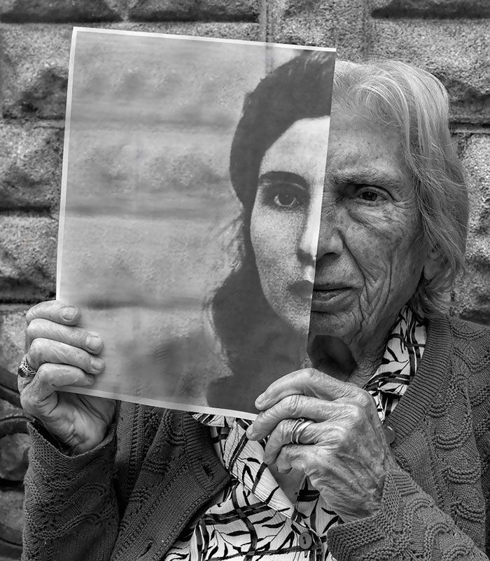 an old woman holding up a poster with the words time will change