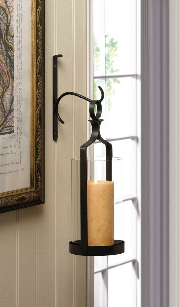 a candle is hanging on the wall next to a window