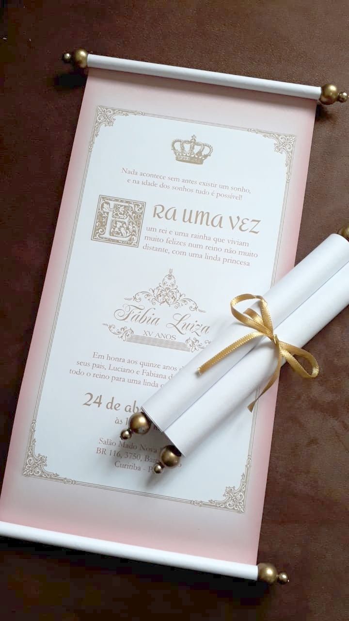 a white paper with a gold ribbon tied around it on top of a brown table