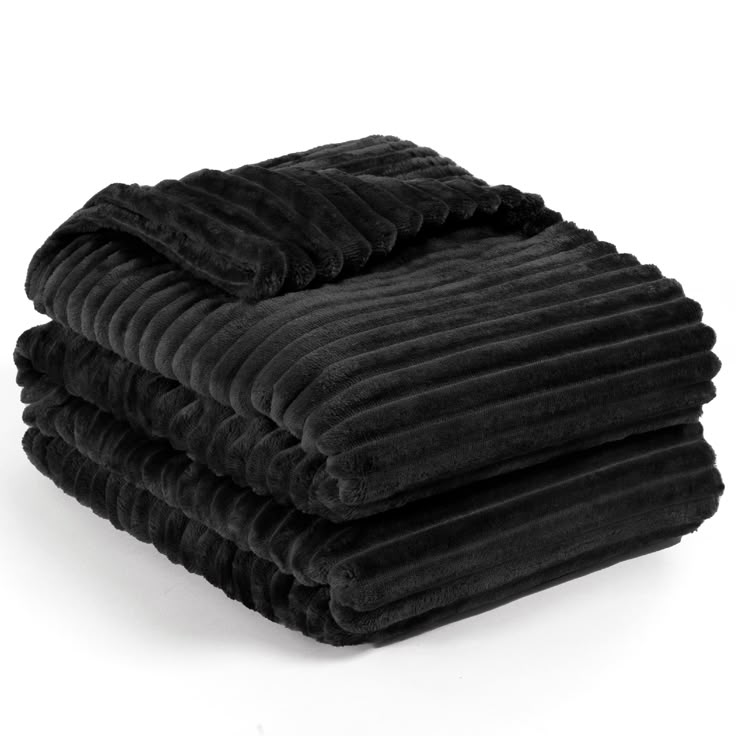 three black blankets stacked on top of each other in front of a white background,