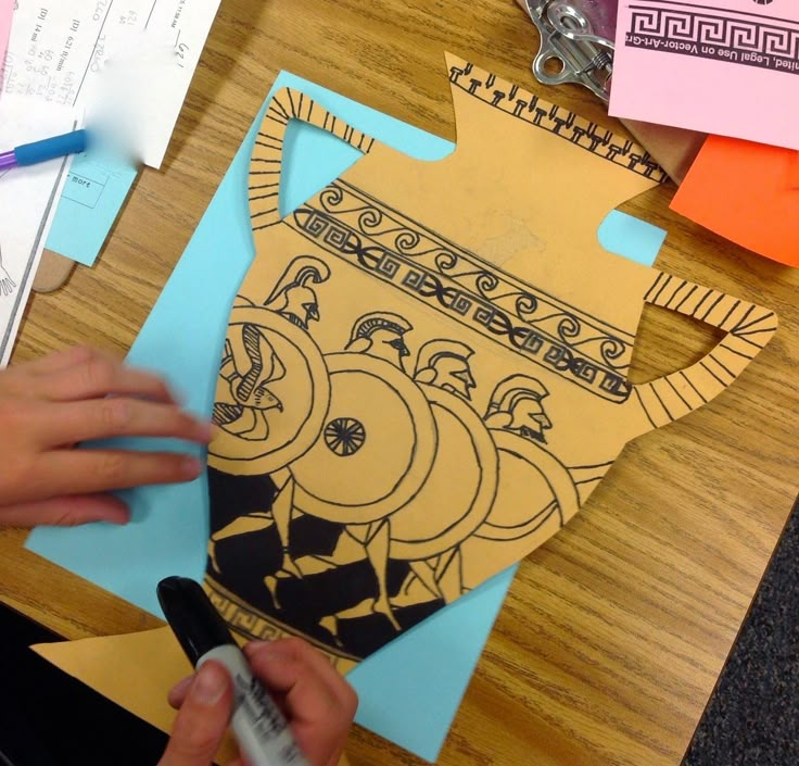 someone is cutting out an ornament from paper on a wooden table with scissors