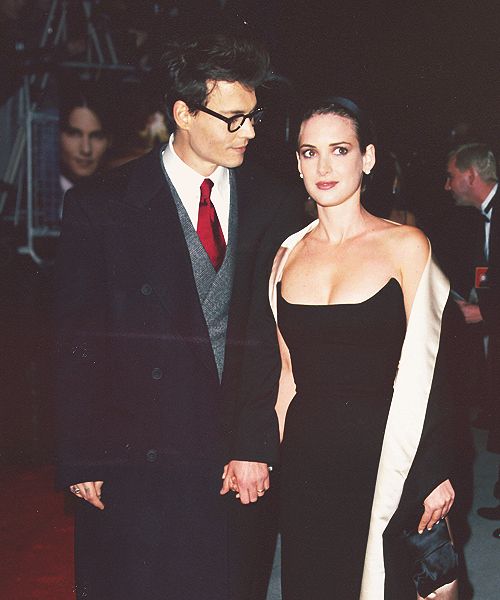 a man and woman dressed in formal wear walking together on the red carpet at an event