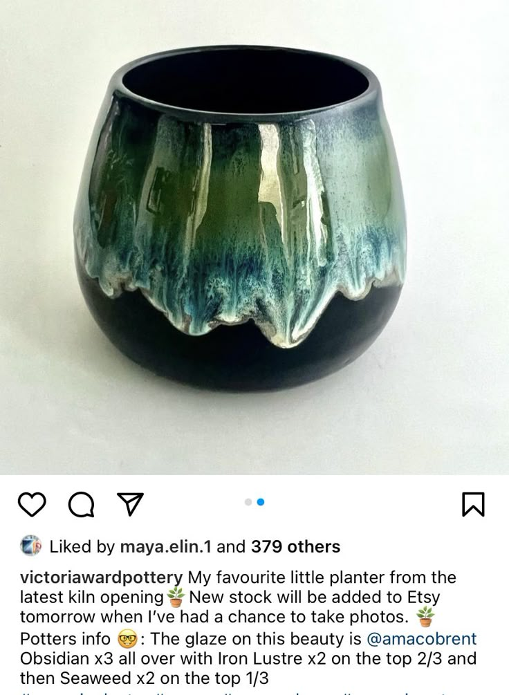 a black and green vase sitting on top of a white table next to a tweet