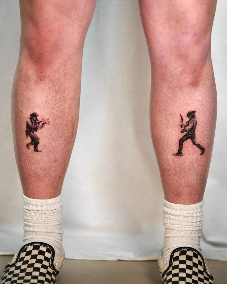 the legs and ankles of a person with tattoos on them, holding a baseball bat