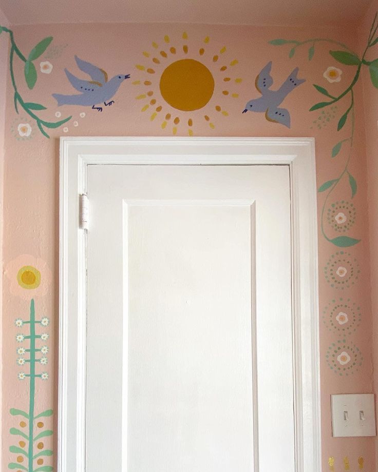 a white door sitting inside of a bathroom next to a wall with flowers and birds painted on it