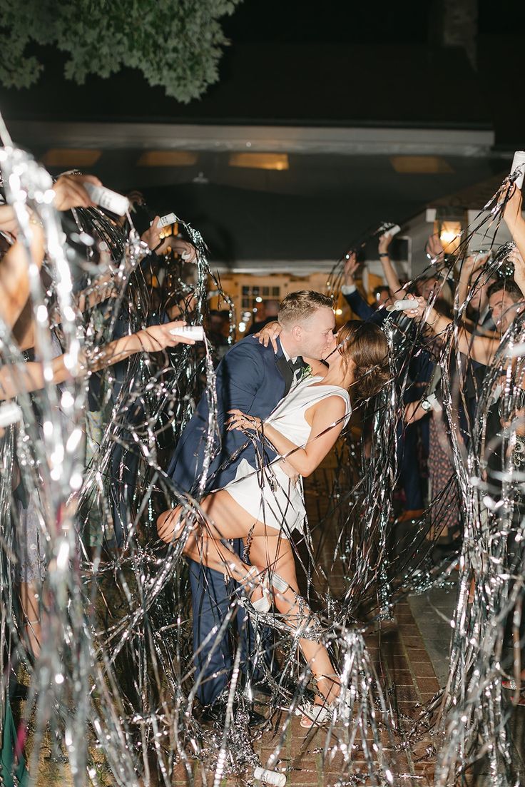 a man and woman kissing surrounded by streamers of confetti on the dance floor