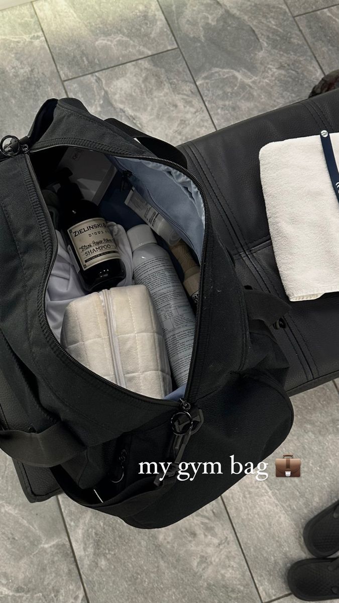 an open black bag sitting on top of a tiled floor