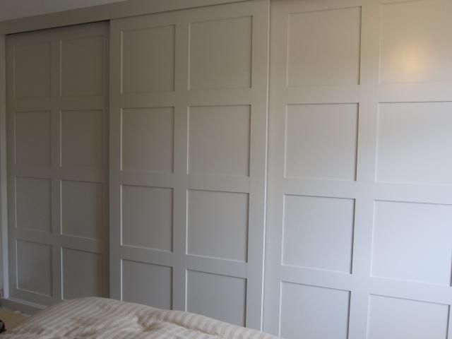 an empty bedroom with white closet doors