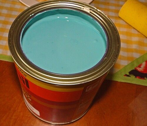 a can of blue paint sitting on top of a wooden table