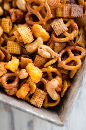 a metal pan filled with cheetos and nuts