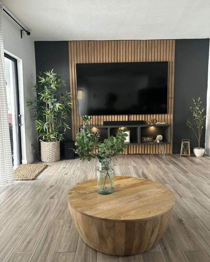 a living room filled with furniture and a flat screen tv mounted on a wall above a wooden coffee table