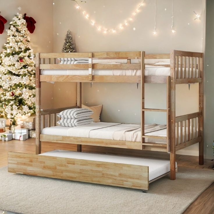 a bunk bed sitting next to a christmas tree in a room with lights on the ceiling