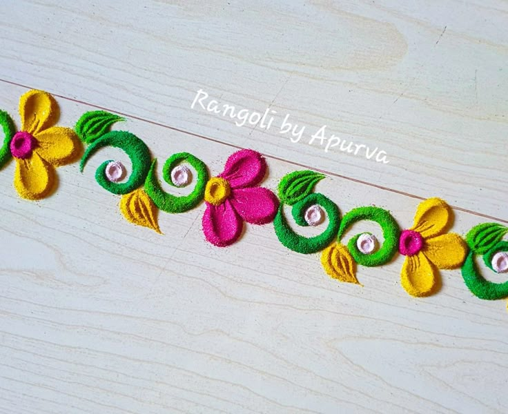 an embroidered ribbon with flowers and leaves is shown on a wooden surface, along with the words ranggol by apurva