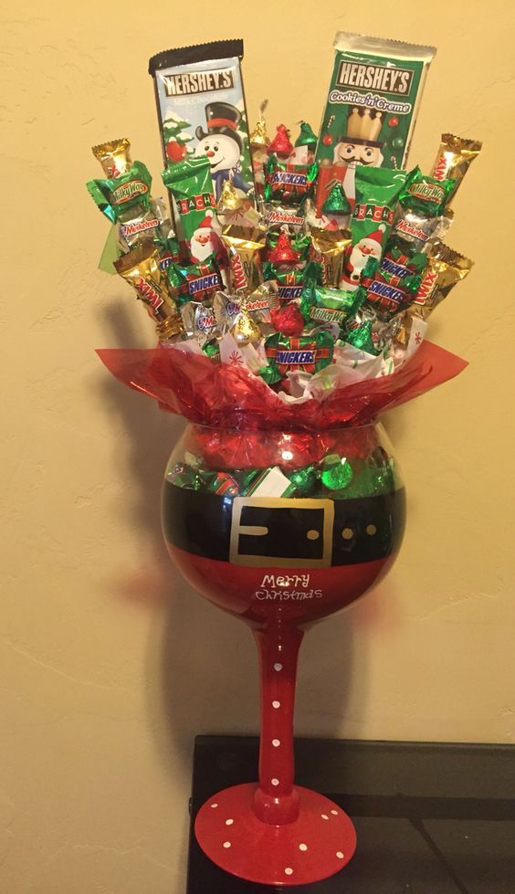 a red vase filled with lots of candy and candies on top of a table