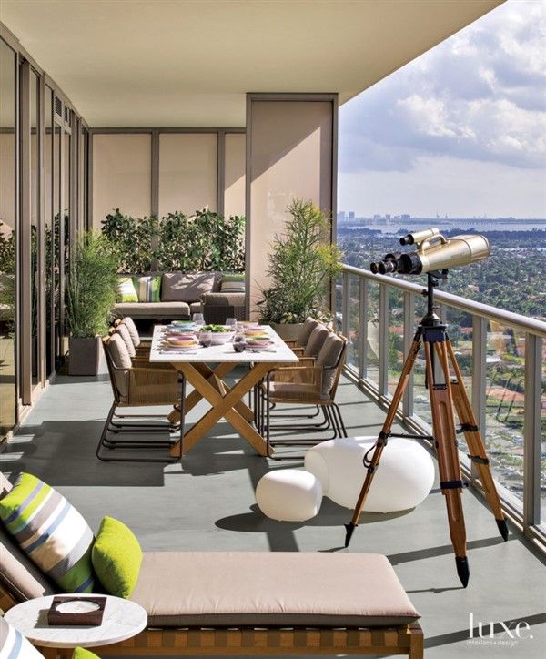 a balcony with furniture and a telescope on the table