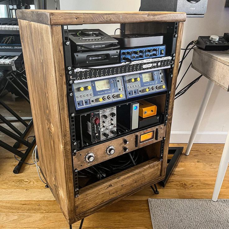 a large wooden case with many electronic equipment in it's centerpiece on top of a hard wood floor