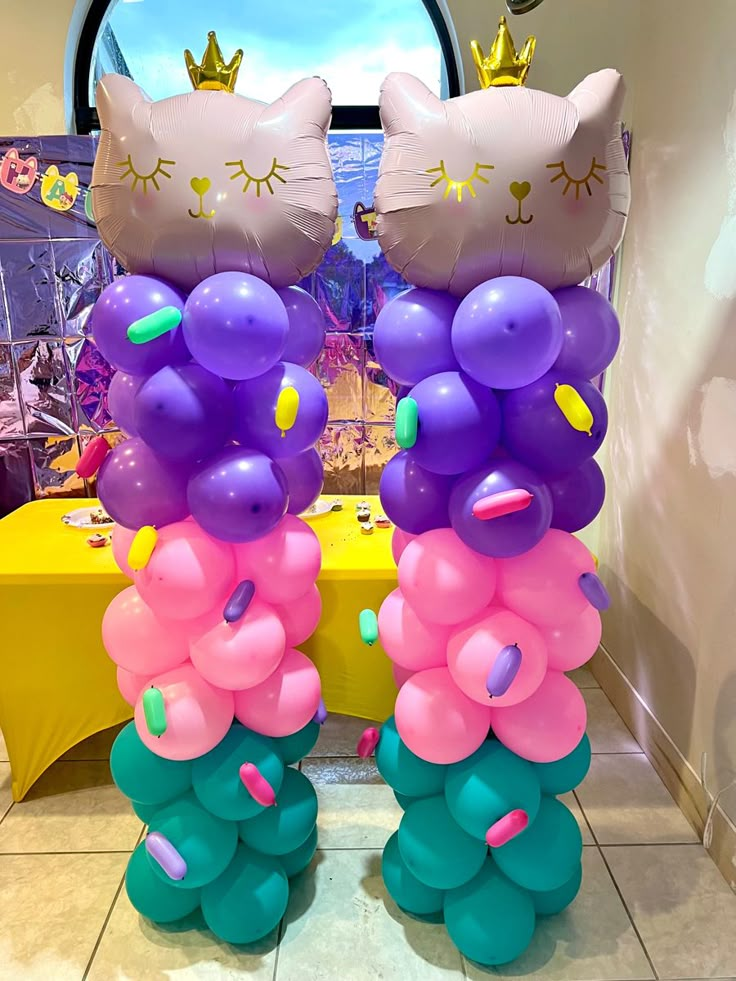 two large balloons with cats on them in the shape of flowers and hearts are standing next to each other