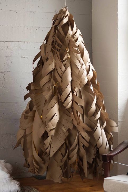 a christmas tree made out of strips of cardboard sitting on top of a wooden floor