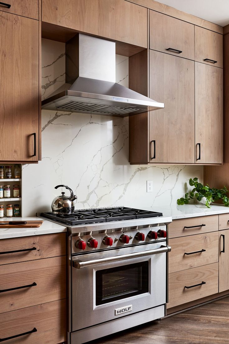 a stove top oven sitting inside of a kitchen next to wooden cabinets and counter tops