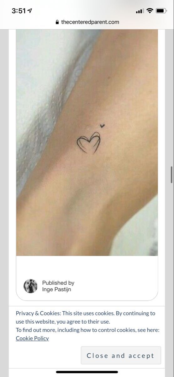 a small heart tattoo on the left side of the arm, with an arrow in the middle