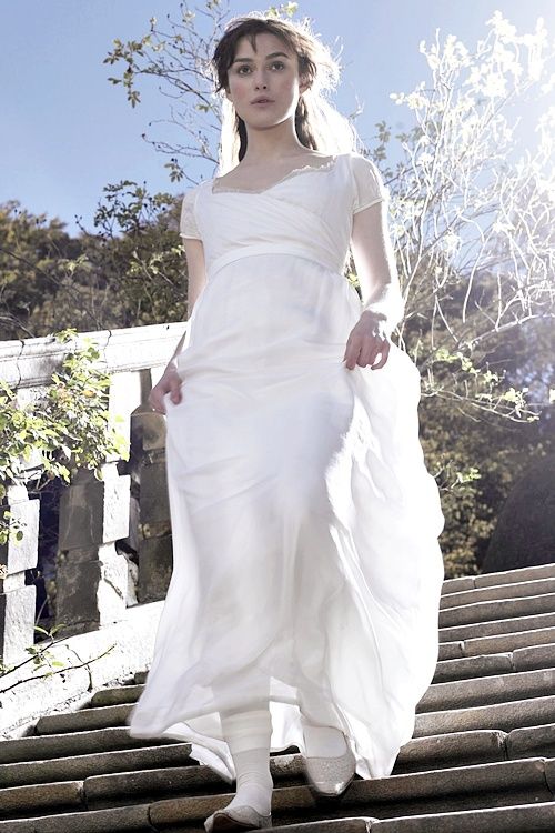 a woman in a white dress is walking down some steps