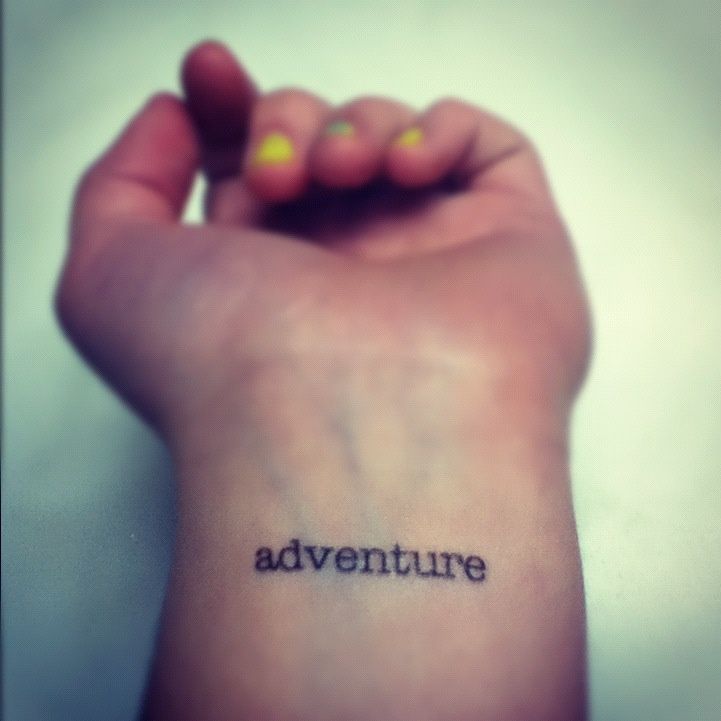 a person's arm with the word adventure written on it, in black ink