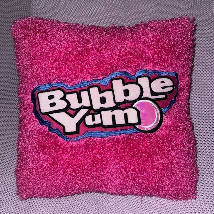 a pink pillow with the word bubble yum on it