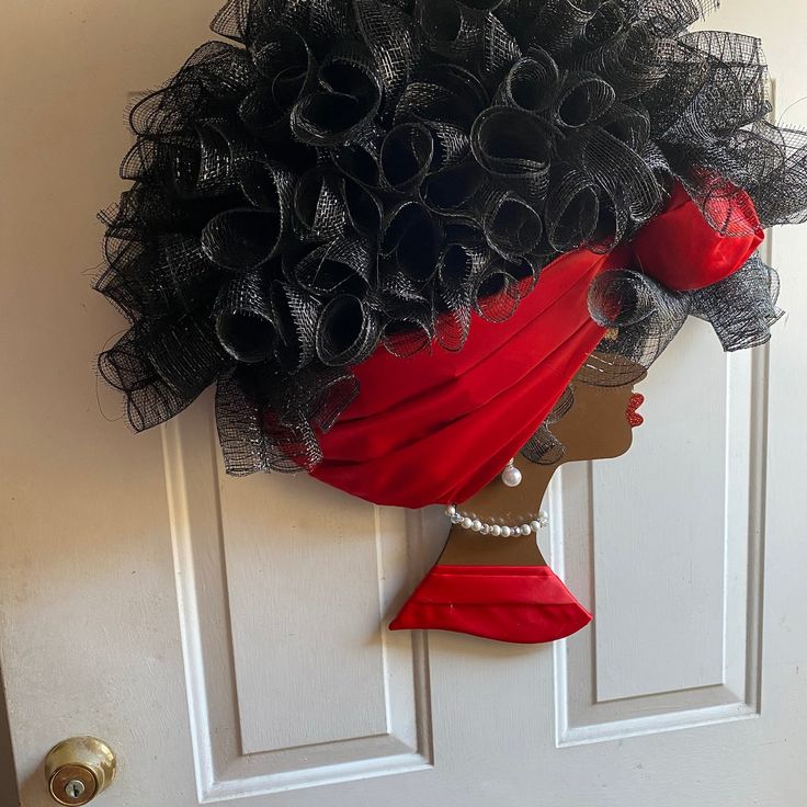 a woman's head is adorned with black tulle and red apple hairpiece