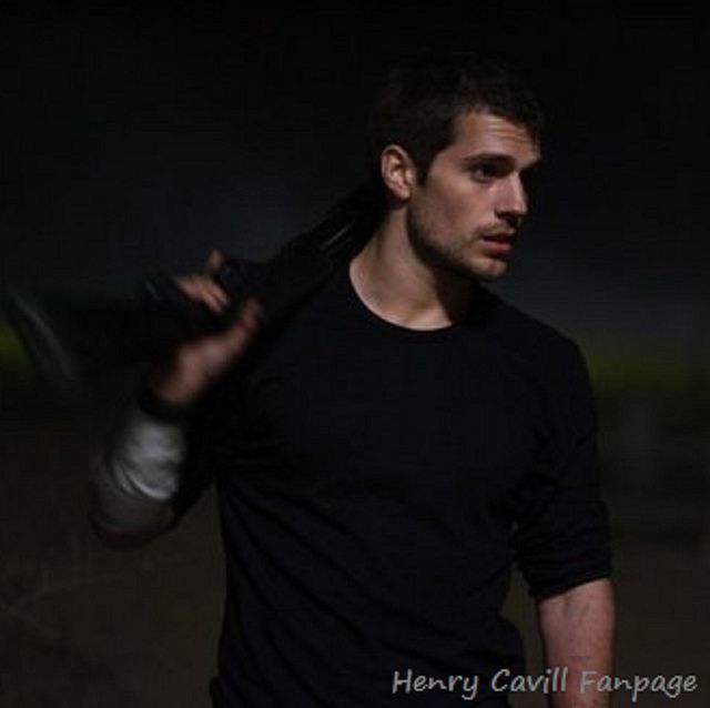 a man in black shirt holding a tennis racquet on top of his shoulder