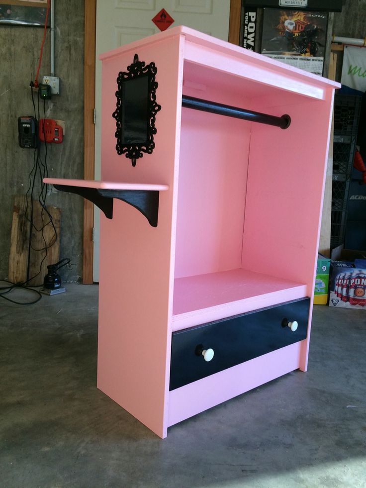 a pink and black cabinet sitting on top of a cement floor next to a door