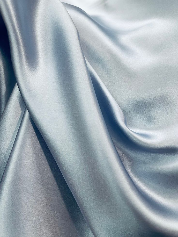 a close up shot of a silver satin fabric with very soft folds and wrinkles