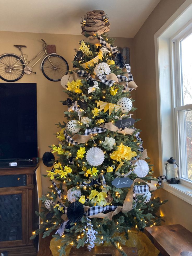 a christmas tree decorated with yellow and white flowers