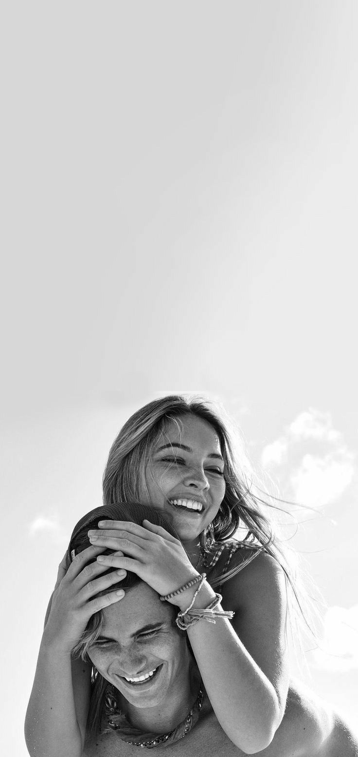 black and white photograph of two women hugging each other with sky in the back ground