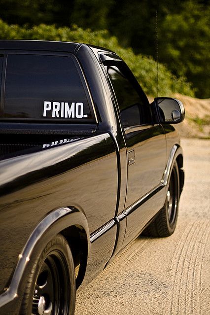 a black pickup truck parked on the side of a road