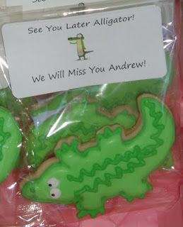 there is a plastic bag with some cookies in the shape of alligators and an envelope that says see you later alligator we will miss you andrews