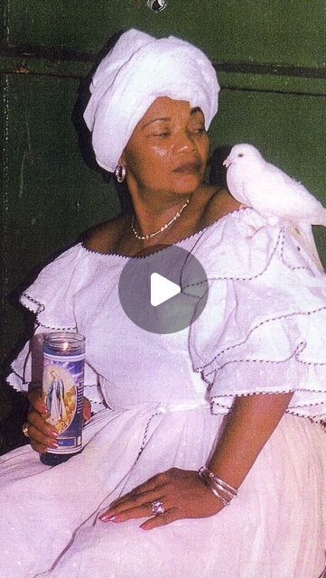 a woman in a white dress holding a can of beer and a bird on her shoulder