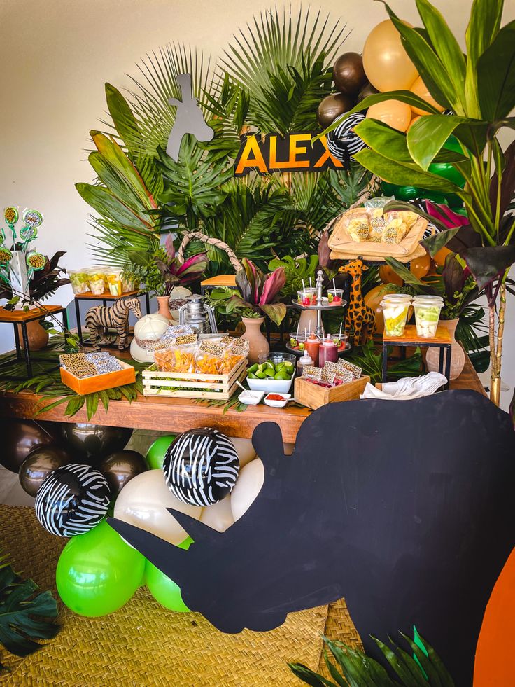 an animal themed birthday party with balloons and jungle decorations