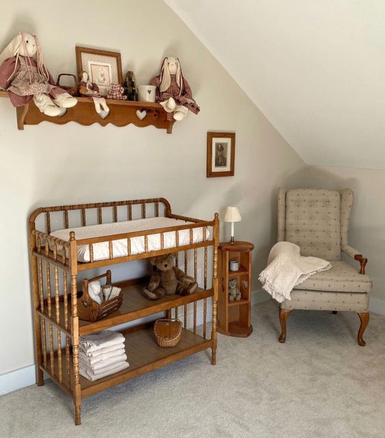 a baby's room with a crib, chair and pictures on the wall