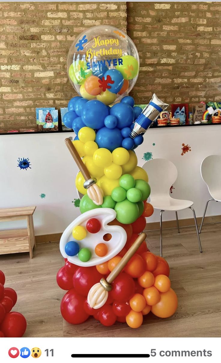 a bunch of balloons are stacked on top of each other in the shape of a tower