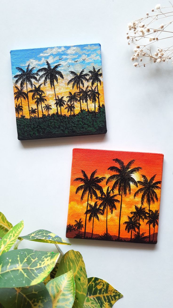 two coasters with palm trees painted on them next to a plant and potted plant