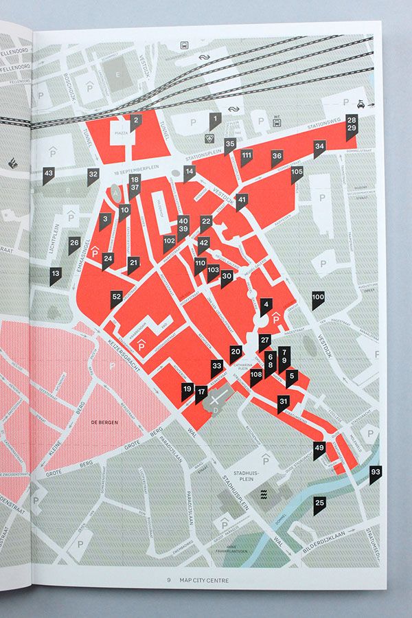 an open book with red and black maps on the pages, which are marked in small squares