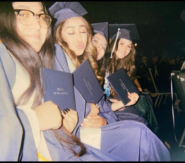 a group of young women sitting next to each other in graduation caps and gowns