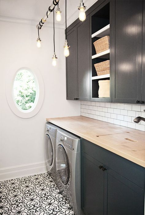 a washer and dryer in a small room with wood counter tops on the floor