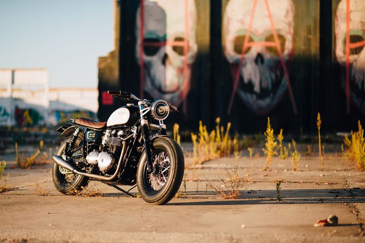 a motorcycle is parked in front of some graffiti