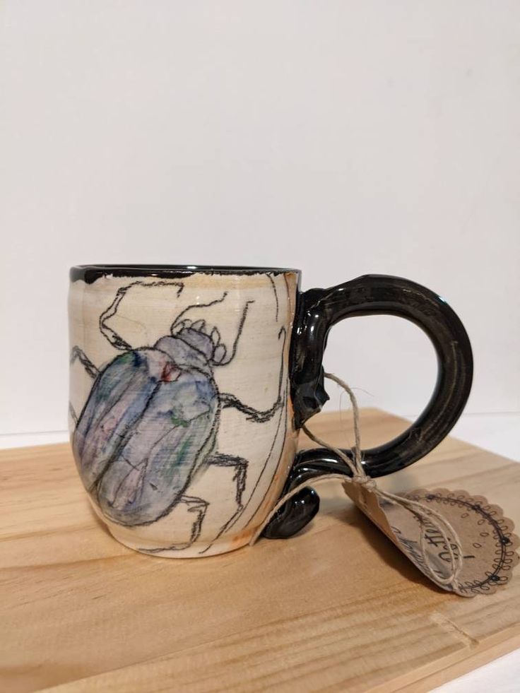 a coffee cup with a bug painted on it