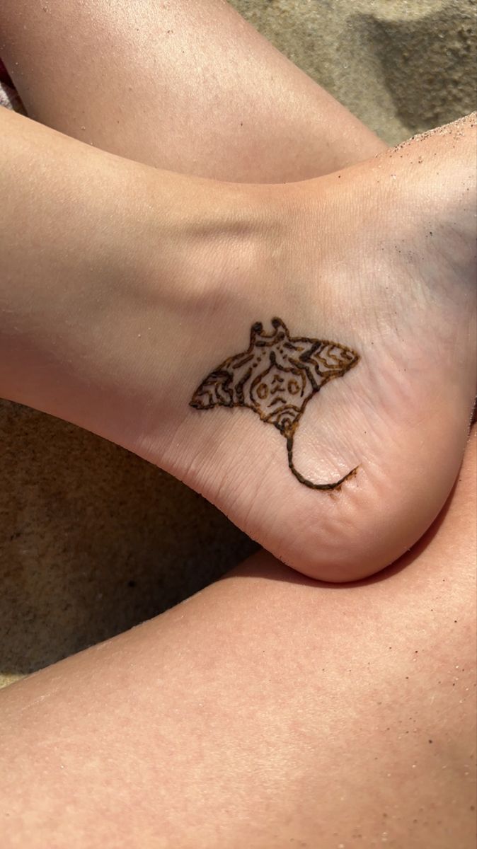 a woman's foot with a tattoo on the side of her leg and an animal