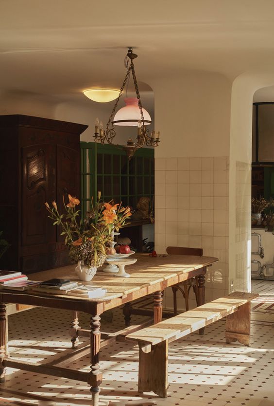 a dining room table with two benches in front of it and a potted plant on the table