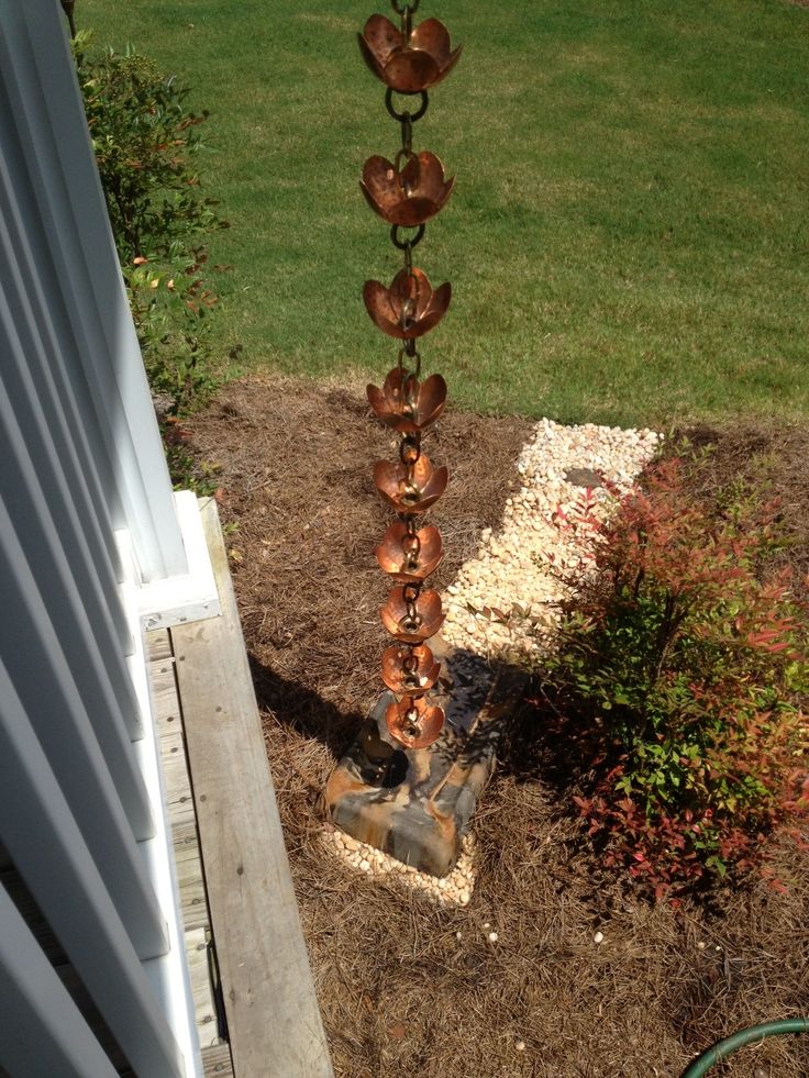 a tall metal tree with hearts on it's branches in the yard next to a house