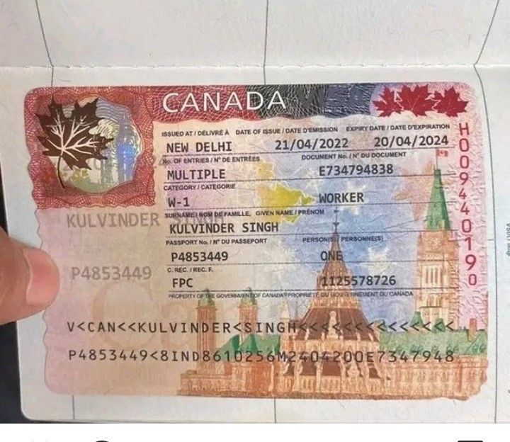 the canadian visa is being held up by someone's hand